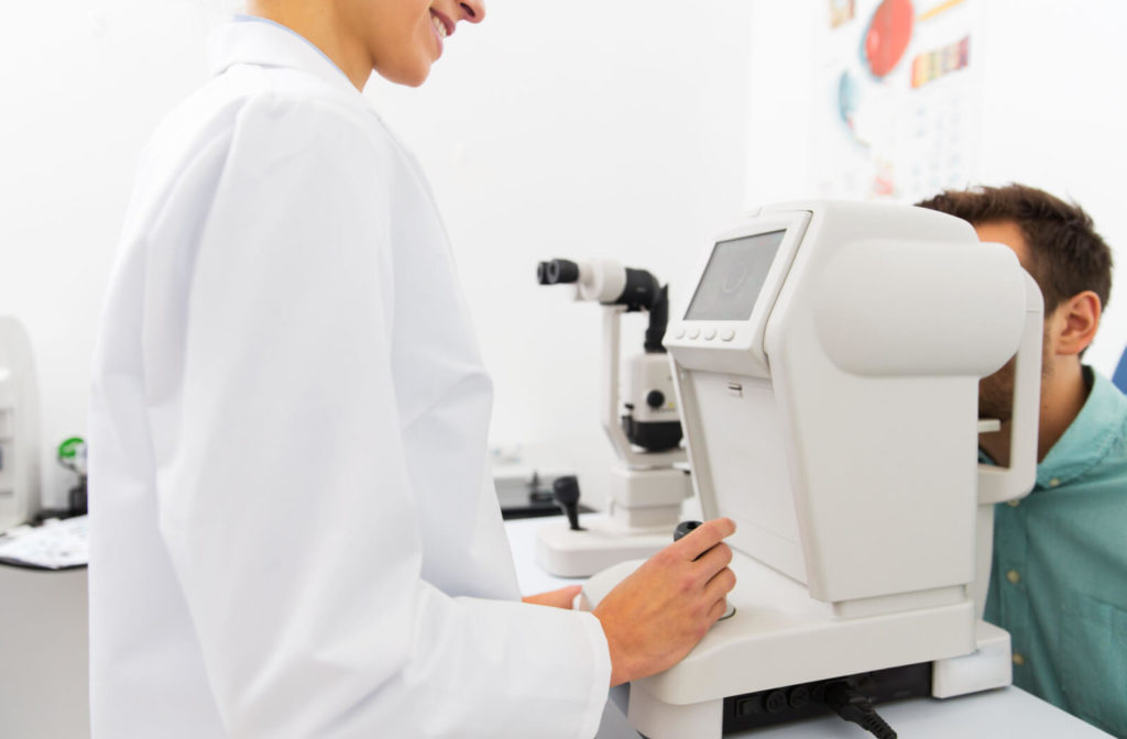 A female optician is doing an eye exam on a male patient with the use of an autorefractor to get an automated assessment of refraction.