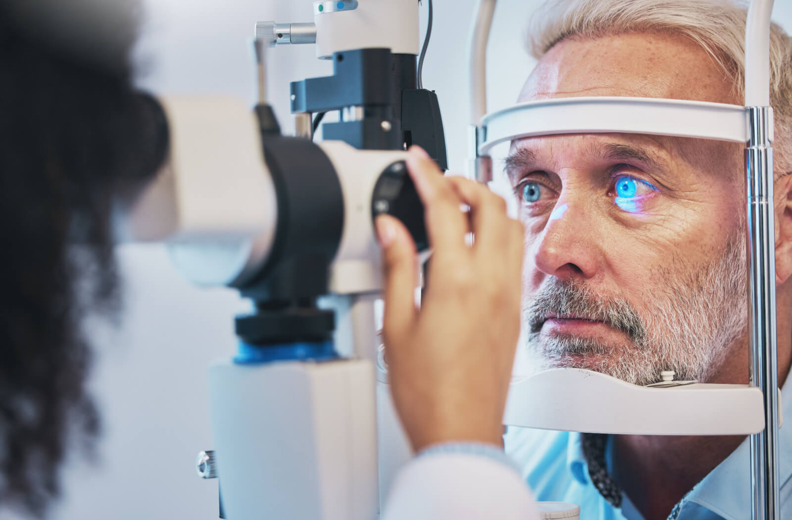 A blue-eyed senior man undergoing a diabetic eye exam.