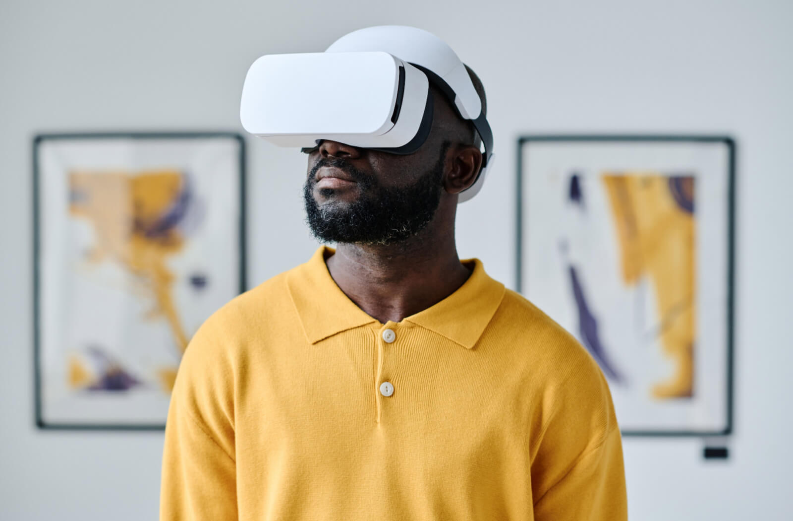 A man wearing a yellow shirt using a VR headset.