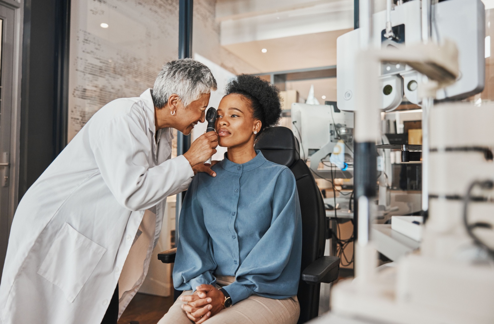 An optometrist examines her patient's ocular health to diagnose her symptoms.