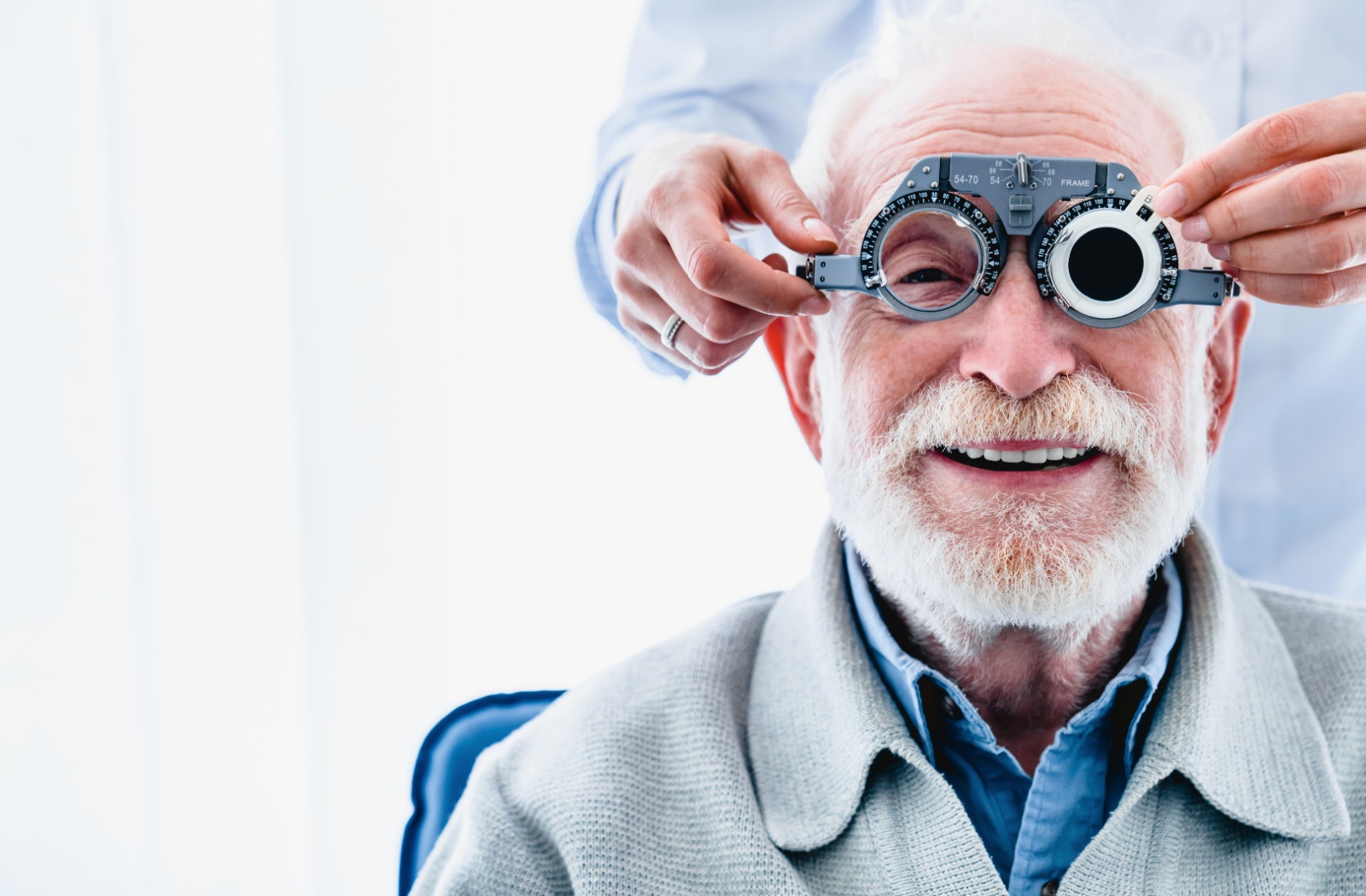 Portrait of a happy senior patient undergoing vision check with special ophthalmic glasses.