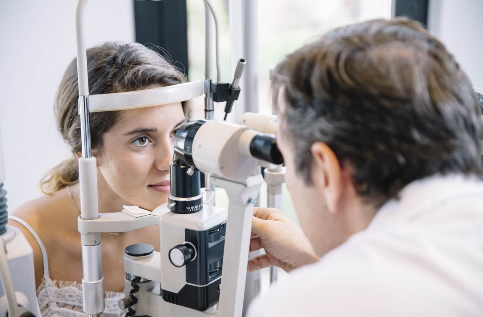 A young adult gets an eye examination to ensure their eyeglasses prescription is up to date.