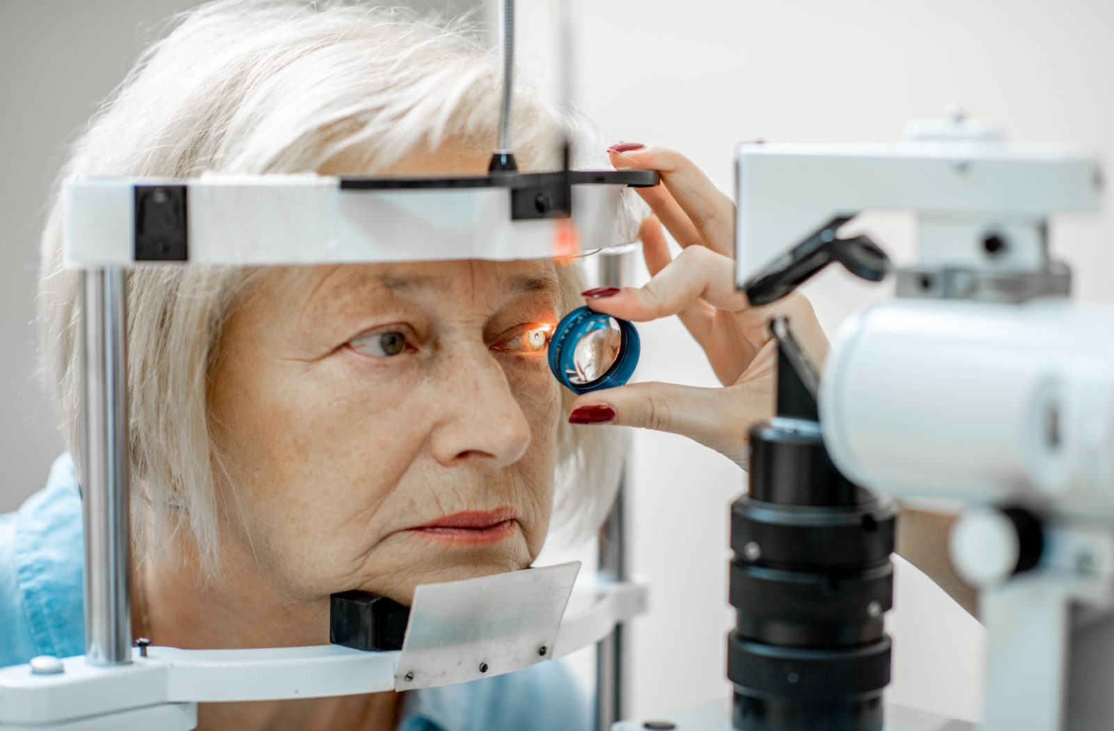 Older adult undergoing a slit-lamp eye exam with optometrist checking for signs of cataracts