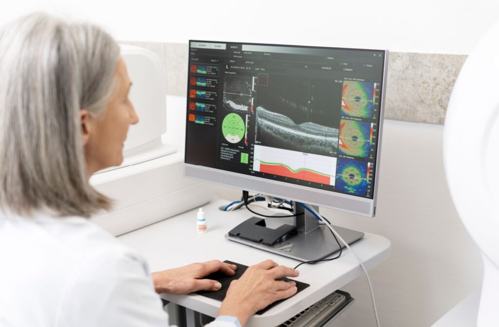 An optometrist examines their patient's optical coherence tomography test.