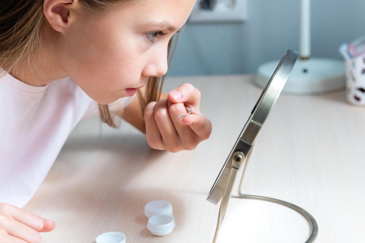 Young patient applying contact lenses